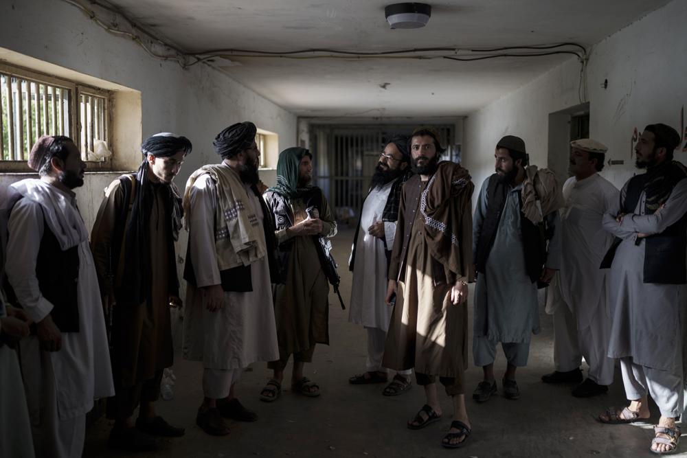 Combatientes talibanes, algunos de ellos antiguos reos, charlan en una zona vacía del penal de Pul-e-Charkhi, en Kabul, Afganistán, el 13 de septiembre de 2021. Pul-e-Charkhi era la principal prisión en la que el gobierno retenía a los talibanes capturados y era conocida por los abusos, las malas condiciones y el hacinamiento, con miles de reos entre sus muros. Ahora, tras hacerse con el control del país, el Talibán gestiona también el penal, que alberga a alrededor de 60 personas, en su mayoría drogadictos y delincuentes acusados. (AP Foto/Felipe Dana)