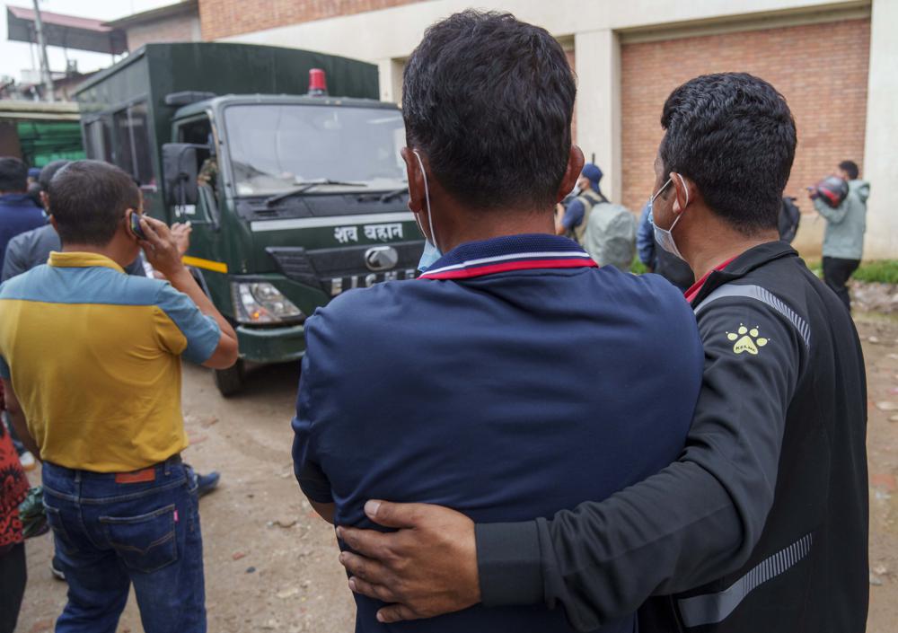 Los familiares lloran cuando un vehículo que transportaba los cuerpos de las víctimas de un accidente aéreo llega a un hospital en Katmandú, Nepal, el martes 31 de mayo de 2022. Los rescatistas que buscan en la ladera de una montaña en Nepal recuperaron el martes los cuerpos de las 22 personas que estaban a bordo de un avión que se estrelló el domingo.  (Foto AP/Niranjan Shrestha)