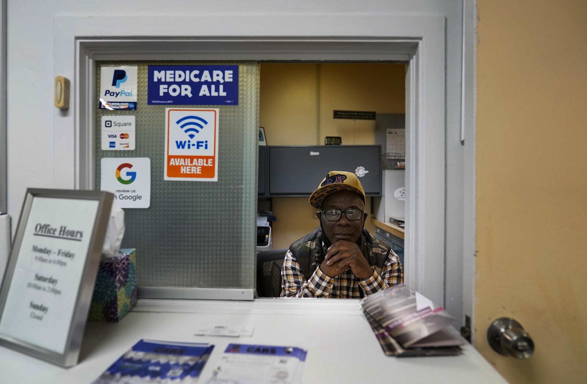 Jerome Anderson sits behind a window in a clinic where he distributes Narcan and other medical supplies in St. Louis on Wednesday, May 19, 2021. (AP Photo/Brynn Anderson)