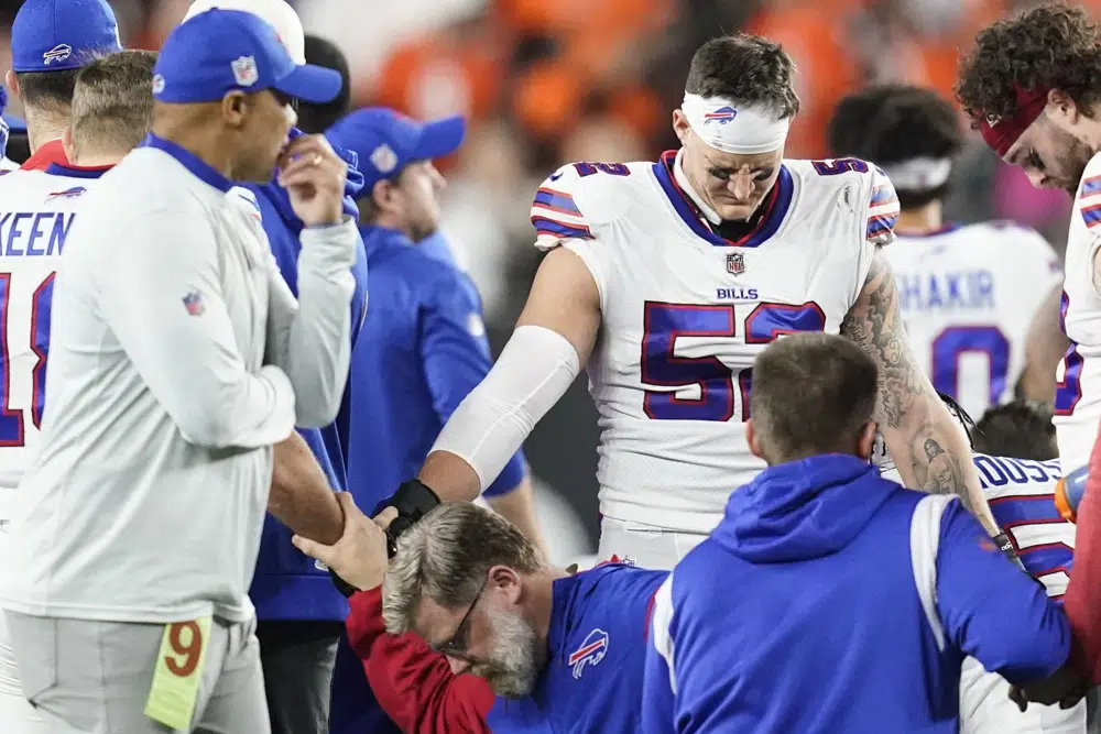 FILE - Buffalo Bills players and staff pray for Buffalo Bills' Damar Hamlin during the first half of an NFL football game against the Cincinnati Bengals, Monday, Jan. 2, 2023, in Cincinnati. When medical personnel rushed onto the field to save Damar Hamlin’s life after the Buffalo Bills’ defensive back collapsed during a game last month in Cincinnati, many people witnessing the horrifying scene did the only thing they could to help. They prayed.(AP Photo/Joshua A. Bickel, File)