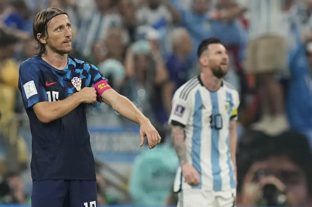 Croatia's Luka Modric adjusts his armband in front of Argentina's Lionel Messi during the World Cup semifinal soccer match between Argentina and Croatia at the Lusail Stadium in Lusail, Qatar, Tuesday, Dec. 13, 2022. (AP Photo/Martin Meissner)