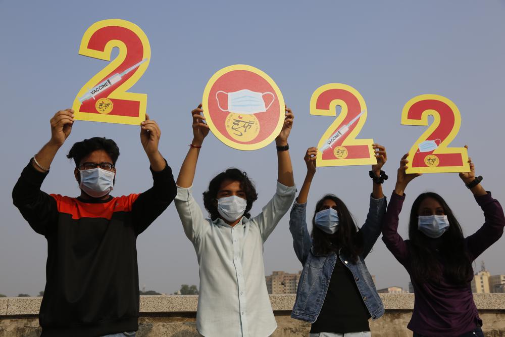 Los indios, con máscaras faciales para ayudar a frenar la propagación del coronavirus, sostienen los recortes para dar la bienvenida a 2022 en la víspera de Año Nuevo en Ahmedabad, India, el viernes 31 de diciembre de 2021 (AP Photo / Ajit Solanki).
