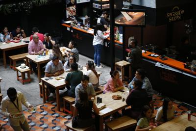 Comensales en la plaza de negocios de comida Huerto Roma, el 10 de julio de 2021, en la Ciudad de México. (AP Foto/Ginnette Riquelme)