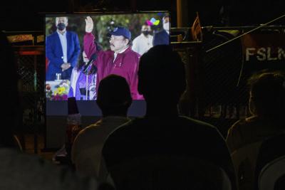 ARCHIVO - Residentes ven la toma de posesión del actual presidente Daniel Ortega, por cuarto mandato consecutivo, en una pantalla gigante instalada en un parque en el barrio Julio Buitrago de Managua, Nicaragua, el 10 de enero de 2022. La administración Biden está considerando tratar de expulsar a Nicaragua de un lucrativo pacto regional de libre comercio para tomar represalias contra la represión de Ortega contra sus oponentes. (AP Foto/Andrés Núñez, Archivo)