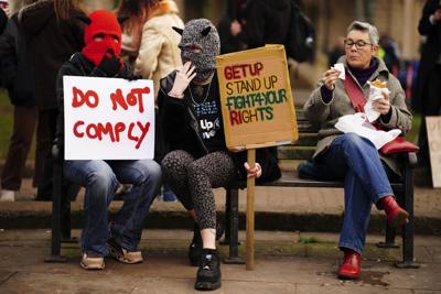Manifestantes con pancartas durante una protesta en Bristol, Inglaterra, el sábado 15 de enero de 2022. Los manifestantes marcharon en Londres, bristol, Coventry, Newcastle, Liverpool, Sheffield, Plymouth y otros lugares antes de la tramitación parlamentaria de una propuesta de ley que limita las manifestaciones el 17 de enero. Los carteles dicen "No obedezcan" y "Levántense y plántense, luchen por sus derechos". (Ben Birchall/PA via AP)