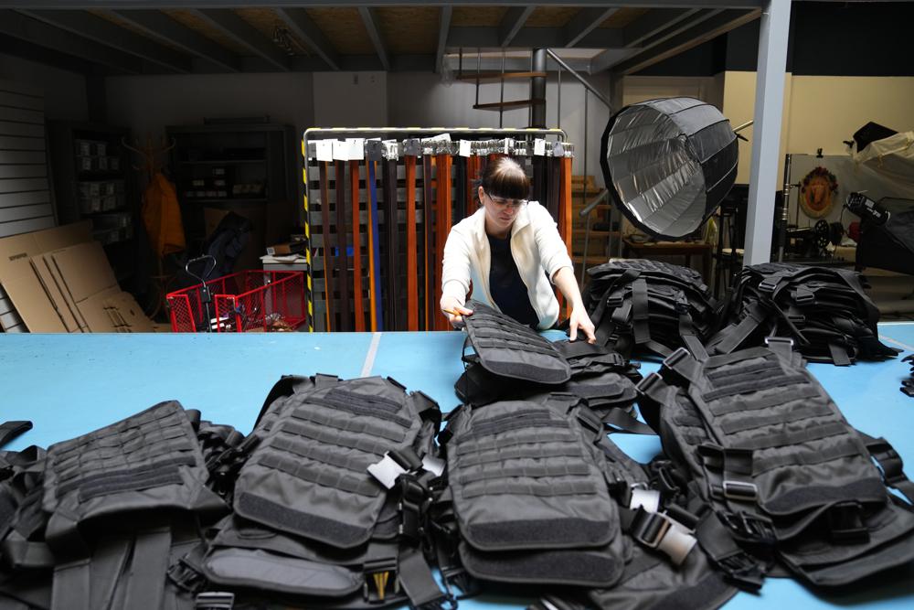 A Ukrainian worker sorts newly produced body armor at a leatherwork shop in Prague, Czech Republic, Thursday, April 21, 2022. A Czech leatherwork company that makes a wide variety of handmade products — travel bags, wallets and belts — never intended to add personal protective gear that would save lives in a war to its offerings. But the Russian invasion of Ukraine has changed all that. After Russian troops launched their assault, Tlusty & Co. has hired 15 Ukrainian refugees to help it manufacture body armor for Ukraine's volunteer defenders. (AP Photo/Petr David Josek)