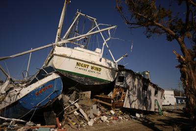 Camaroneros apilados junto a un edificio de departamentos en Fort Myers Beach (Florida) el 7 de octubre del 2022. Los pesqueros terminaron en tierra firme tras el paso del huracán Ian. (AP Photo/Rebecca Blackwell)