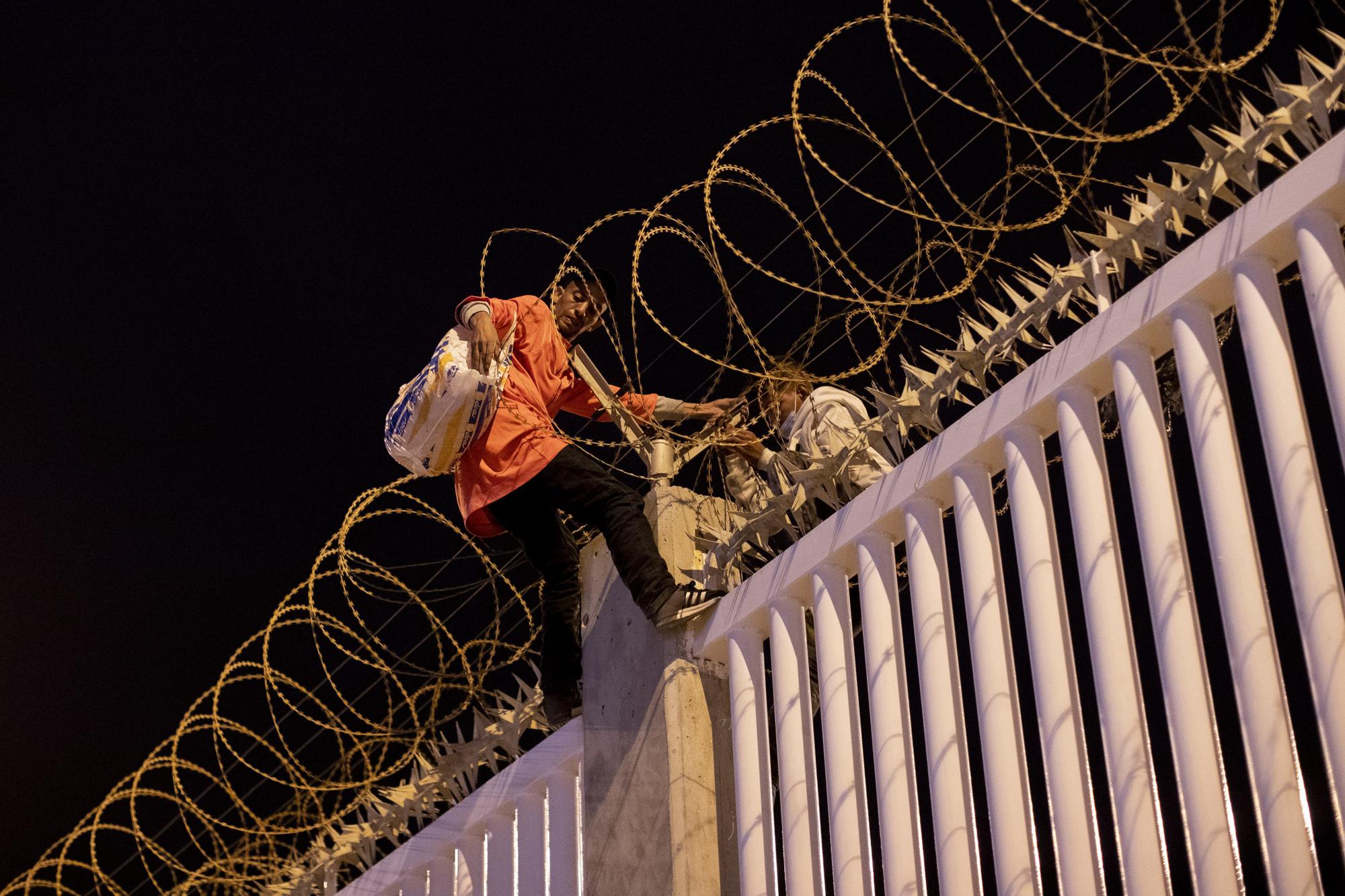 Migrants who recently crossed the Spain Morocco border, cross into the Ceuta commercial port, Spain, Wednesday, May 19, 2021. The group explained to The Associated Press their goal to reach the European ports of Malaga or Algeciras after hiding inside a commercial boat. (AP Photo/Bernat Armangue)