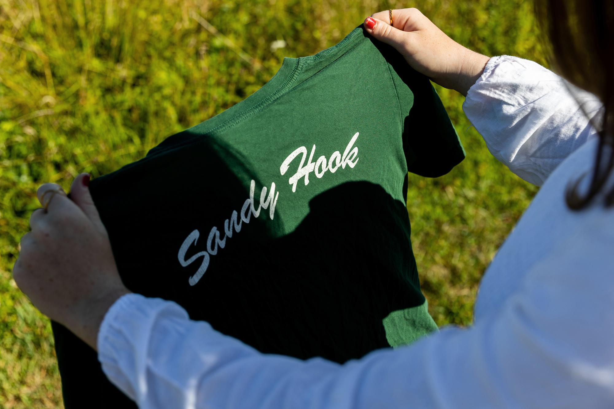 Jackie Hegarty, a rising senior at Newtown High School, holds a Sandy Hook Elementary School t-shirt, Thursday, Aug. 18, 2022, in Newtown, Conn. (AP Photo/Julia Nikhinson)