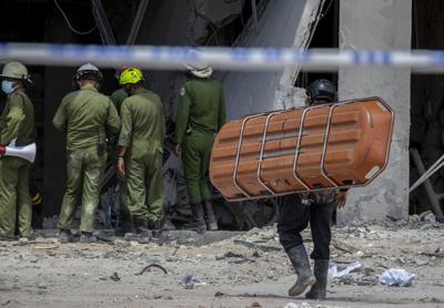 Un miembro del equipo de rescate carga una camilla para transportar el cuerpo de una persona fallecida que se encuentra entre los escombros después de una explosión que destruyó el Hotel Saratoga de cinco estrellas en La Habana Vieja, Cuba, el domingo 8 de mayo de 2022. (Foto AP/ Ismael Francisco)