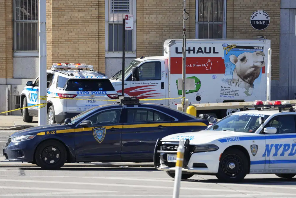 Police vehicles surround a truck that was stopped and the driver arrested, Monday, Feb. 13, 2023, in New York. Police stopped the U-Haul truck and detained the driver after reports that the vehicle struck multiple pedestrians in New York City on Monday. Authorities say the driver of the truck fled the scene after mounting a sidewalk in the Bay Ridge neighborhood of Brooklyn and injuring several people. (AP Photo/John Minchillo)