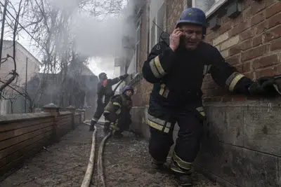 Un trabajador de rescate habla por teléfono mientras su equipo apaga un incendio en una casa que fue bombardeada por las fuerzas rusas en el barrio residencial de Kostiantynivka, Ucrania, el viernes 10 de marzo de 2023. (AP Photo/Evgeniy Maloletka)