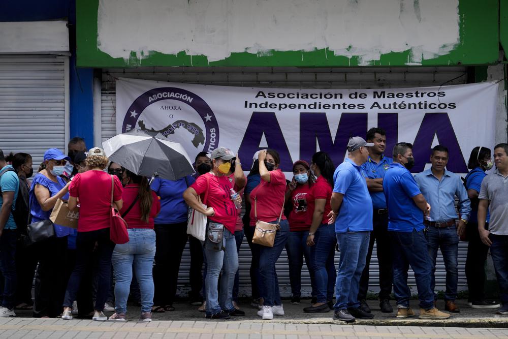 Members of the Teachers Union hold a general assembly as they end their nationwide strike to protest inflation outside the Republica de Venezuela school in Panama City, Monday, Aug. 1, 2022. Teachers continue to negotiate with the government over other issues. (AP Photo/Arnulfo Franco)