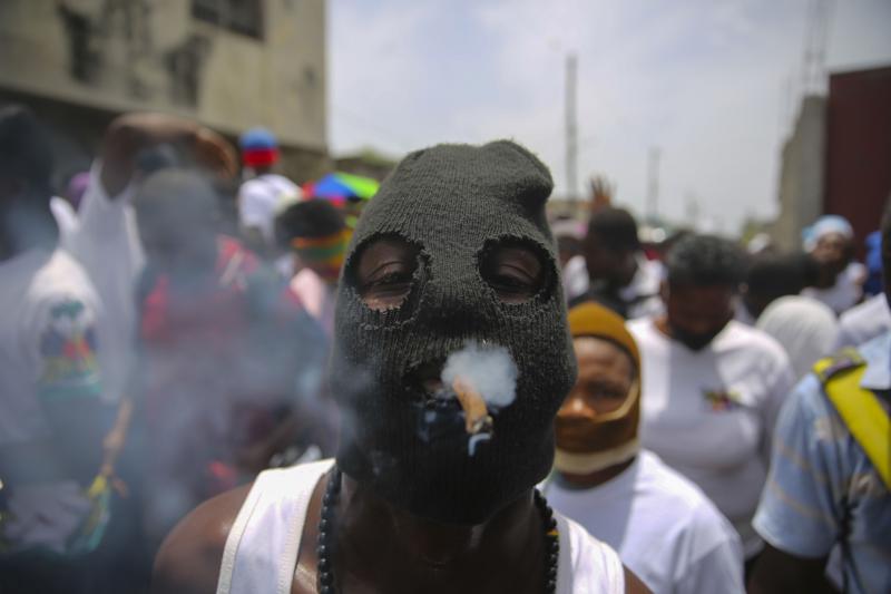 FILE - In this July 26, 2021 file photo, a member of the gang led by Jimmy Cherizier, alias Barbecue, a former police officer who heads a gang coalition known as "G9 Family and Allies,¨ joins a march to demand justice for slain Haitian President Jovenel in Lower Delmas, a district of Port-au- Prince, Haiti. Haiti's government warned Monday, Sept. 6, 2021, about a spike in kidnappings and other crimes as it pledged to fight gangs that in response to the looming crackdown are threatening police with greater violence as the country braces for more instability. (AP Photo/Joseph Odelyn, File)