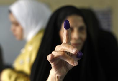 Una mujer iraquí muestra su dedo manchado de tinta tras votar en un centro electoral en las elecciones parlamentarias en Bagdad, Irak, el domingo 10 de octubre de 2021. (AP Foto/Hadi Mizban)