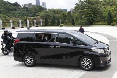 El primer ministro malayo Muhyiddin Yassin saluda desde un auto tras salir del Palacio Nacional, donde se reunió con el rey, en Kuala Lumpur, el lunes, 16 de agosto del 2021. Muhyiddin le presentó su renuncia al rey, reconociendo que no tenia el respaldo de la mayoría para gobernar. (AP Foto/FL Wong)