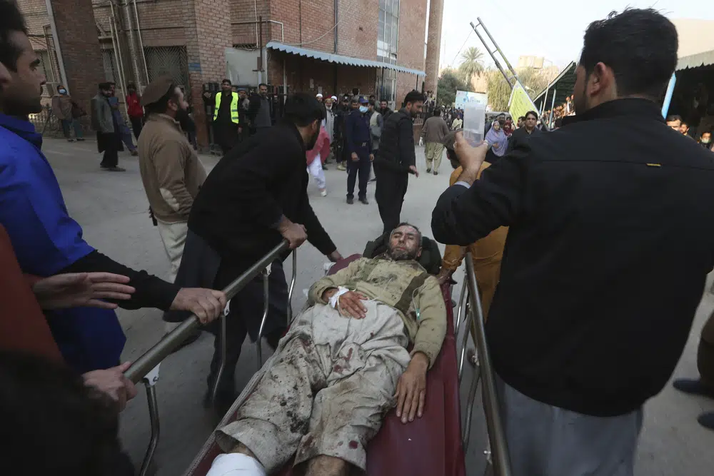 Volunteers carry an injured victim of a suicide bombing upon arrival at a hospital in Peshawar, Pakistan, Monday, Jan. 30, 2023. A suicide bomber struck Monday inside a mosque in the northwestern Pakistani city of Peshawar, killing multiple people and wounding scores of worshippers, officials said. (AP Photo/Muhammad Sajjad)