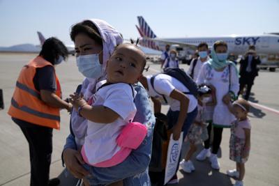 Refugiados afganos abordan un avión a Portugal en el Aeropuerto Internacional Eleftherios Venizelos de Atenas, martes 28 de setiembre de 2021. (AP Foto/Thanassis Stavrakis)