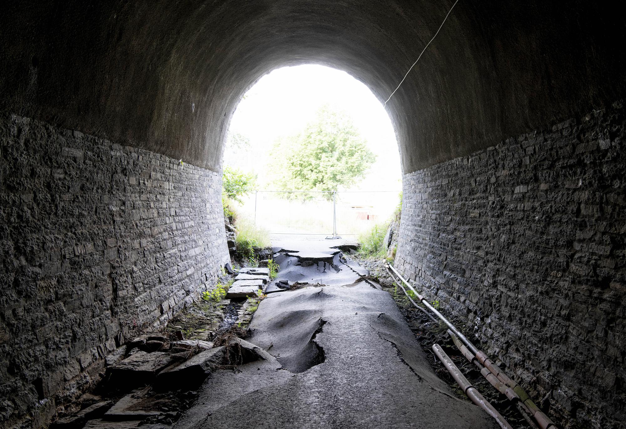 A flood damaged bicycle path goes through a tunnel near the village of Laach in the Ahrtal valley, Germany, Tuesday, July 6, 2022. Flooding caused by heavy rain hit the region on July 14, 2021, causing the death of about 130 people. (AP Photo/Michael Probst)