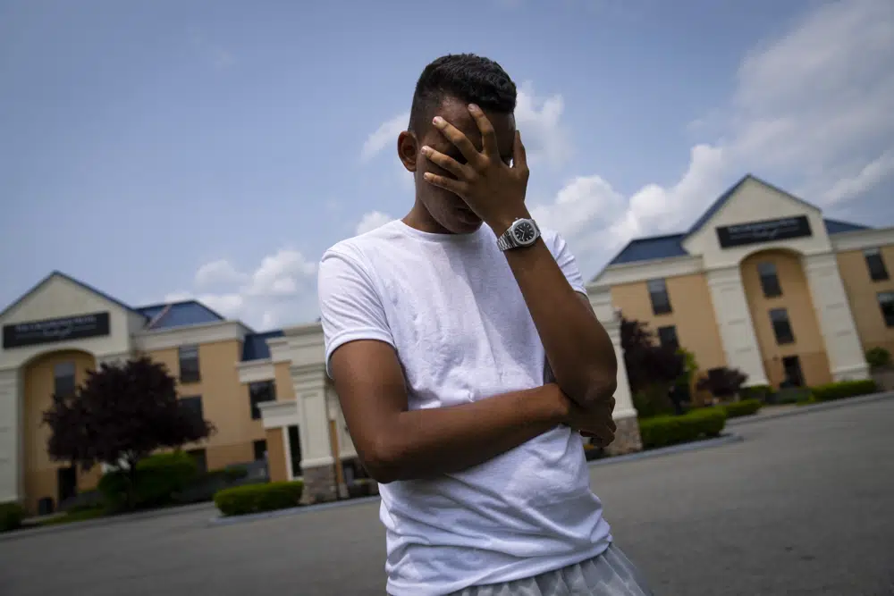 Mohamed, un joven de 19 años que huye de la persecución política en el país de Mauritania, en el noroeste de África, posa para una foto que oscurece su rostro para proteger su identidad, afuera del Crossroads Hotel, antes de dirigirse a la ciudad en busca de una oportunidad laboral, el lunes 22 de mayo. de 2023, en Newburgh, Nueva York, Mohamed es uno de los 400 inmigrantes internacionales que la ciudad ha alojado en una pequeña cantidad de hoteles en otras partes del estado este mes para aliviar la presión sobre su sobrecargado sistema de refugios para personas sin hogar. (Foto AP/John Minchillo)