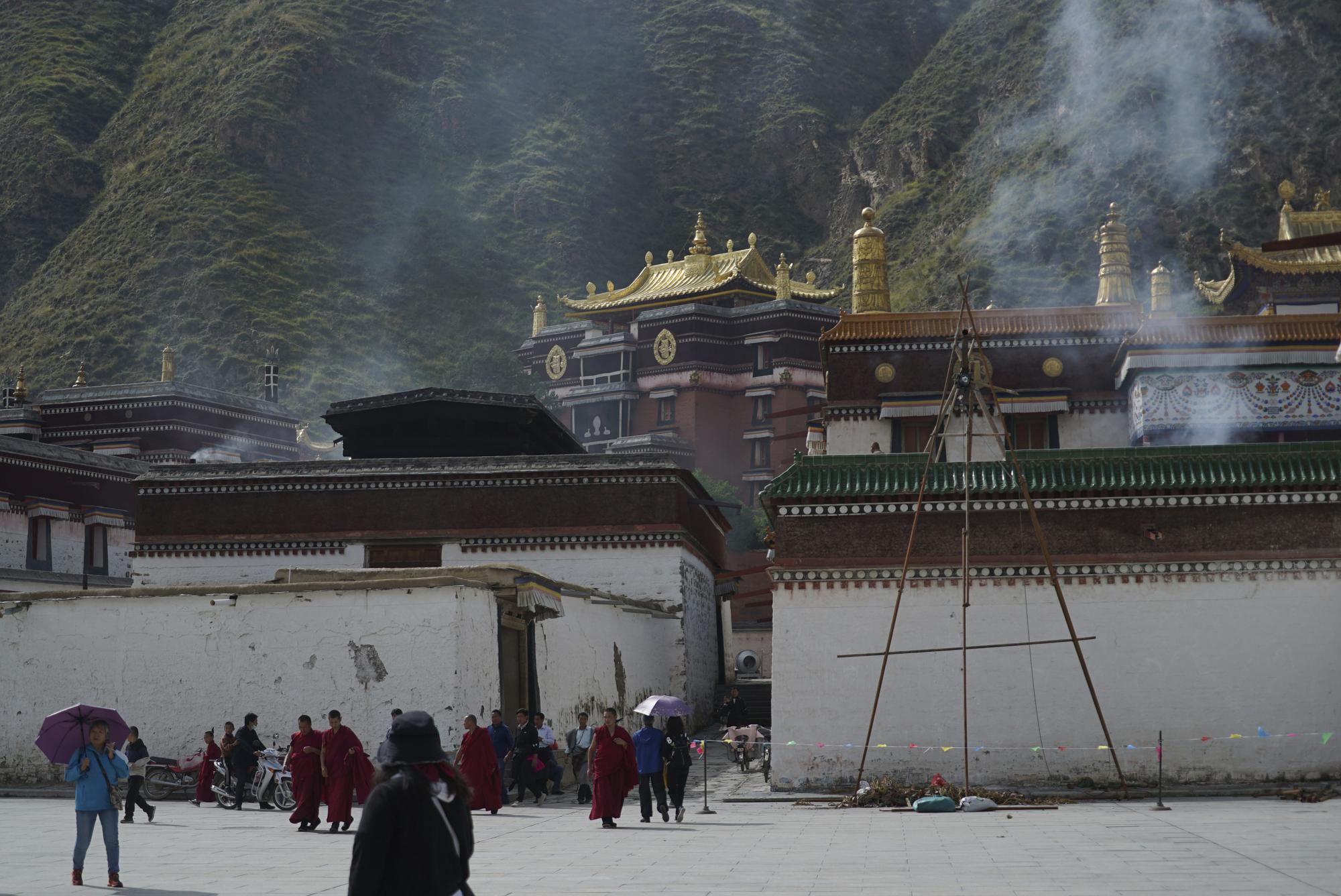 Monks walk in Labrang monastery in Sangqu county, in southwestern China's Sichuan province on Monday, Sept. 19, 2020. Ahead of the Beijing summer Olympics 14 years ago, Tibet was on fire. Deadly clashes between Tibetans and security forces in Lhasa made global headlines, and for weeks, monks and herders battled bullets and batons.  But today, Tibet has fallen silent, even as the Olympic games come to Beijing for a second time. (AP Photo/Dake Kang)