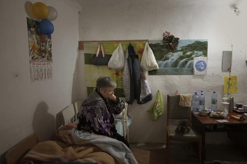 Natalia sits on a makeshift bed, on a shelter builded on the ground floor of her building in Mykolaiv downtown, Ukraine, Monday, Oct. 24, 2022. With the Russian invasion in its ninth month, many Ukrainians no longer ask if their country will be hit by nuclear weapons. They are actively preparing for that once-unthinkable possibility. (AP Photo/Emilio Morenatti)