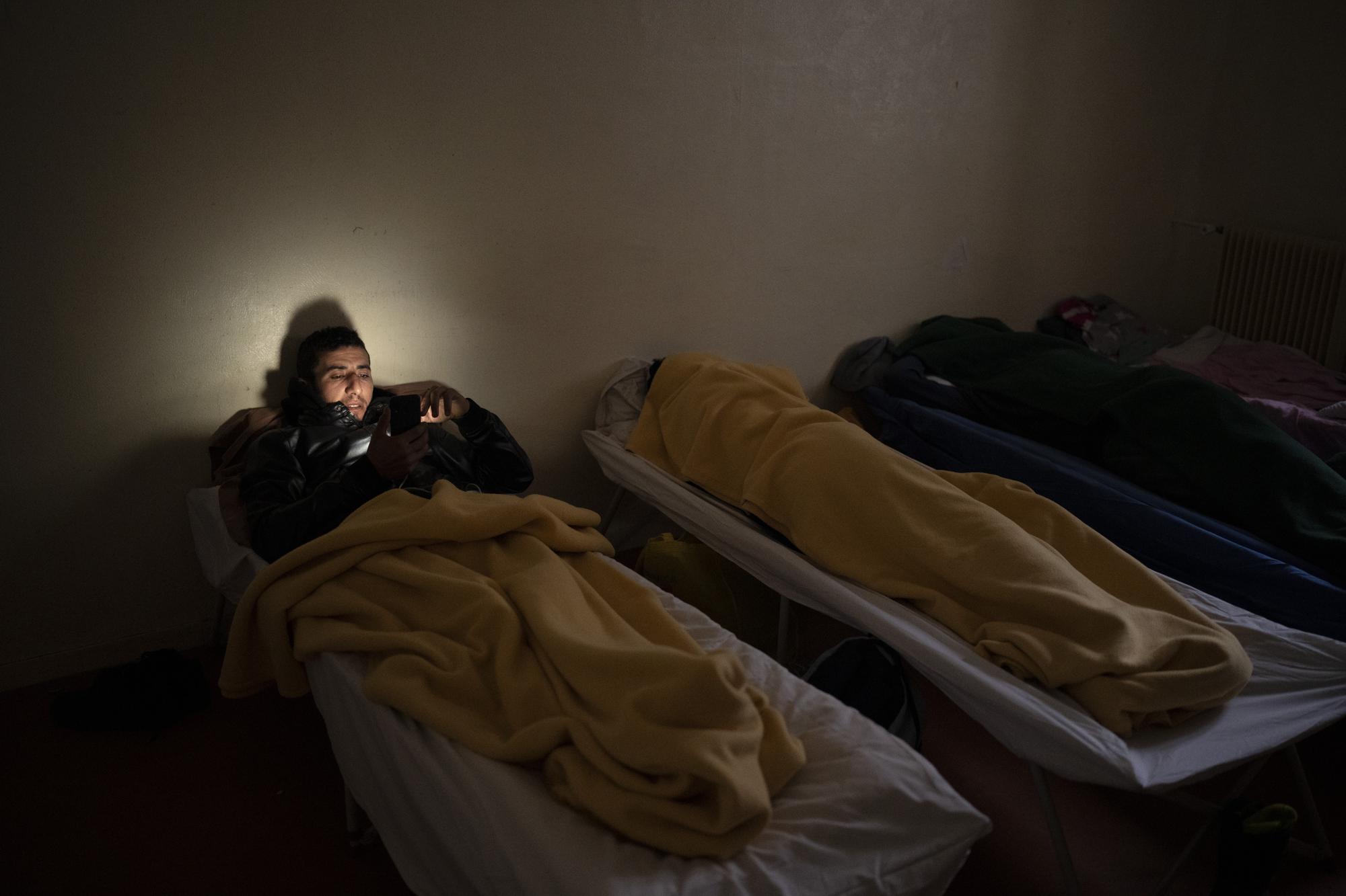 Youssef Alami, 29, from Morrocco rests at a migrant refuge in Briancon, France, after having crossed the French-Italian Alps the day before, Friday, Dec. 10, 2021. (AP Photo/Daniel Cole)