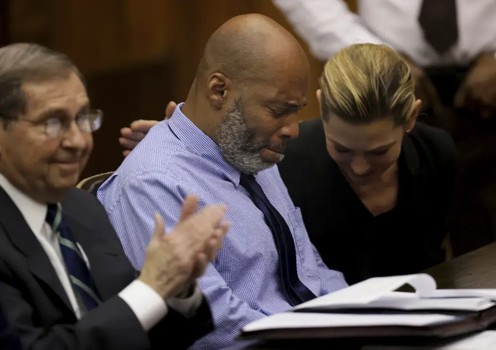 Lamar Johnson, centro y sus abogados reaccionan el martes 14 de febrero de 2023, luego de que el juez de circuito de St. Louis, David Mason, anulara su condena por asesinato durante una audiencia en St. Louis, Mo. Johnson cumplió casi 28 años de cadena perpetua por un matanza que él siempre ha dicho que no cometió. (Christian Gooden/St. Louis Post-Dispatch vía AP, Pool)