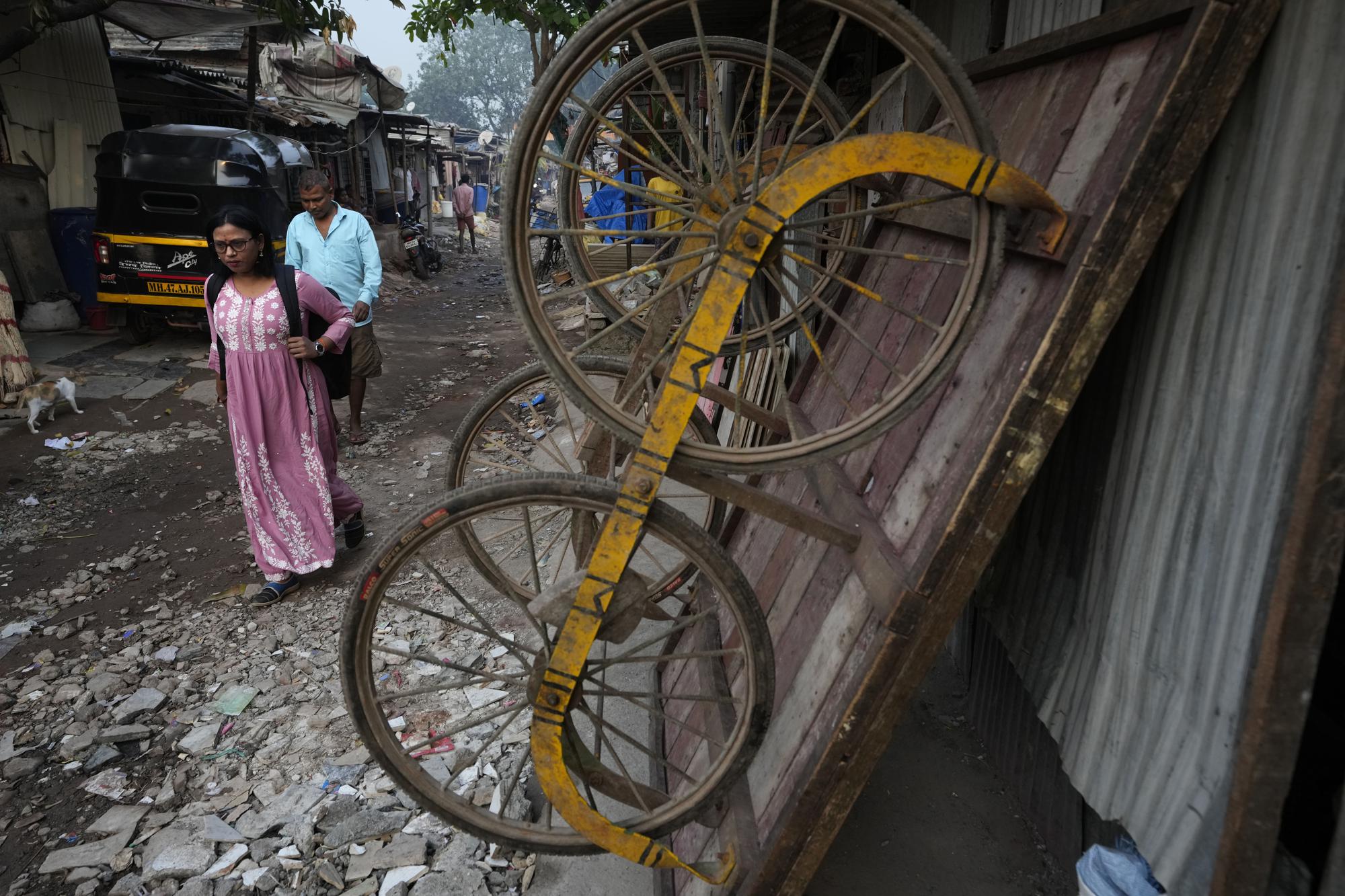 Lalmani Chauhan leaves for office in Mumbai, India, Friday, March 17, 2023. It was the promise of jobs and a better life that drew Chauhan to Mumbai. Back in her village in Uttar Pradesh state, employment prospects were grim. She is the first woman in her family to work - and the first to enroll into university, which she did recently. Her salary is putting her three children - one boy and two girls - through school. (AP Photo/Rajanish Kakade)