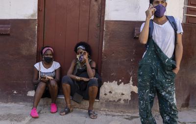 Las personas usan máscaras durante la pandemia de COVID-19 afuera de una tienda de comestibles donde esperan que abra en La Habana, Cuba, el martes 12 de octubre de 2021.
(AP Foto/Ramón Espinosa)