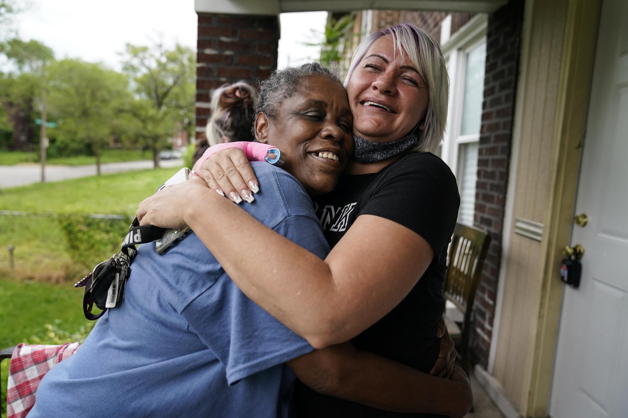 Lynda Brooks, left, hugs Amy Ford in St. Louis on Wednesday, May 19, 2021. Brooks has been in recovery now for several months, and she prays for God to remain scared of the drugs. She got a job and an apartment, and proudly keeps her new keys dangling from a shoelace around her neck. Her family told her they are proud of her. She said that feels like heaven. (AP Photo/Brynn Anderson)