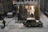 A road crew clears snow during the beginning of a major snow storm, Saturday, Jan. 29, 2022, in Somerville, Mass. A powerful nor'easter swept up the East Coast on Saturday, threatening to bury parts of 10 states under deep, furiously falling snow accompanied by coastal flooding and high winds that could cut power and leave people shivering in the cold weather expected to follow. (AP Photo/Josh Reynolds)