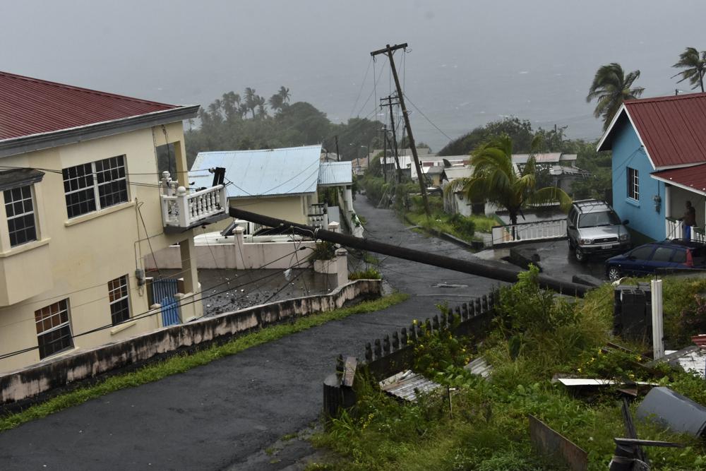 Un poste eléctrico derribado por el huracán Elsa se apoya sobre un balcón el viernes 2 de julio de 2021, en Cedars, San Vicente. (AP Foto/Orvil Samuel)