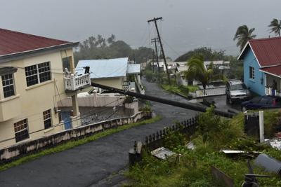 Un poste eléctrico derribado por la tormenta Elsa se apoya sobre un balcón el viernes 2 de julio de 2021, en Cedars, San Vicente. (AP Foto/Orvil Samuel)