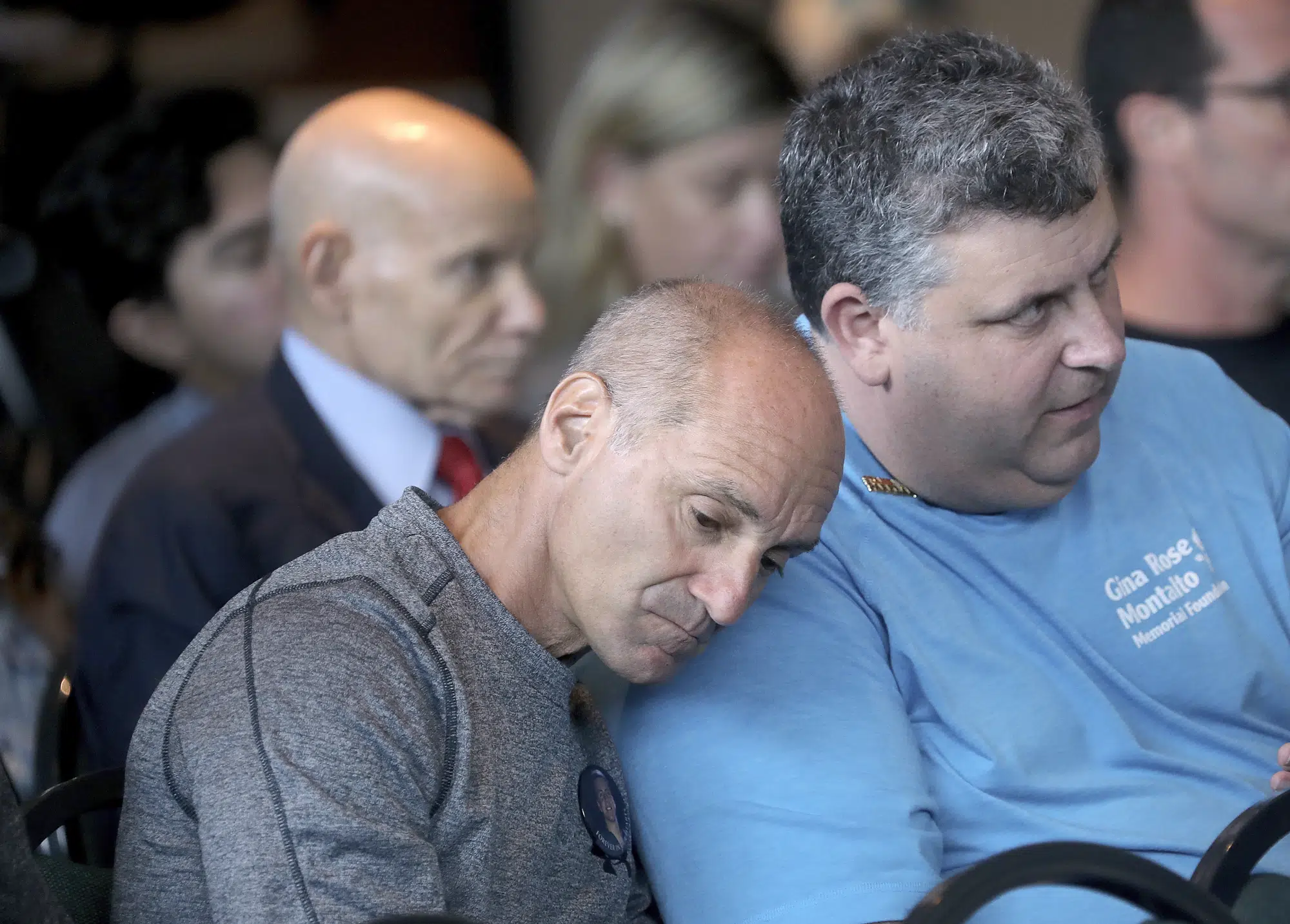 FILE - Mitch Dworet, left, the father of victim Nick Dworet and Tony Montalto, the father of shooting victim Gina Montaldo watch videos from the school shooting during the Marjory Stoneman Douglas High School Public Safety Commission meeting Thursday, Nov 15, 2018 in Sunrise, Fla. (Mike Stocker/South Florida Sun-Sentinel via AP, Pool, File)