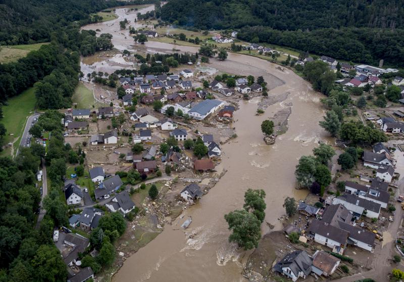 FILE - In this July 15, 2021 file photo the Ahr river floats past destroyed houses in Insul, Germany. Due to heavy rain falls the Ahr river dramatically went over the banks the evening before.  The German government on Wednesday denounced attempts by some people or groups to spread disinformation in areas devastated by floods two weeks ago. (AP Photo/Michael Probst, file)