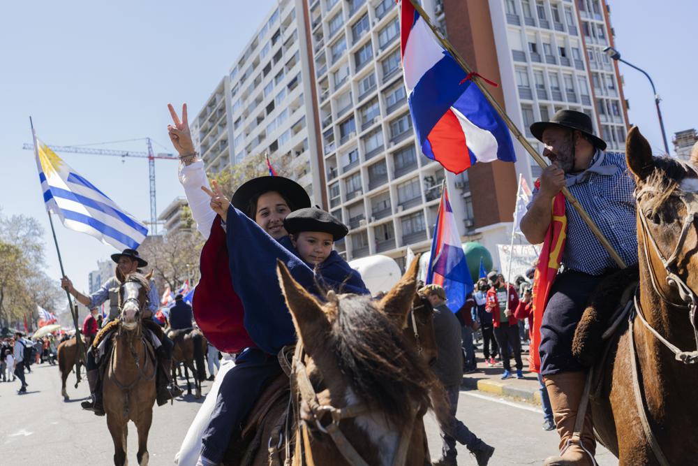 Agricultores a caballo se unen a una marcha durante una huelga general lanzada por la Central Sindical de Trabajadores (PIT-CNT) para protestar por los recortes presupuestarios del gobierno en salud y educación y contra la reducción de los salarios de los trabajadores públicos en Montevideo, Uruguay, el miércoles 15 de septiembre de 2021. (Foto AP/Matilde Campodónico)