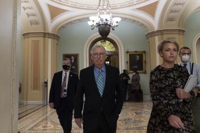 El líder de la minoría republicana en el Senado, Mitch McConnell, al centro, sale de la cámara alta el jueves 7 de octubre de 2021, en el Capitolio, en Washington. (AP Foto/Alex Brandon)