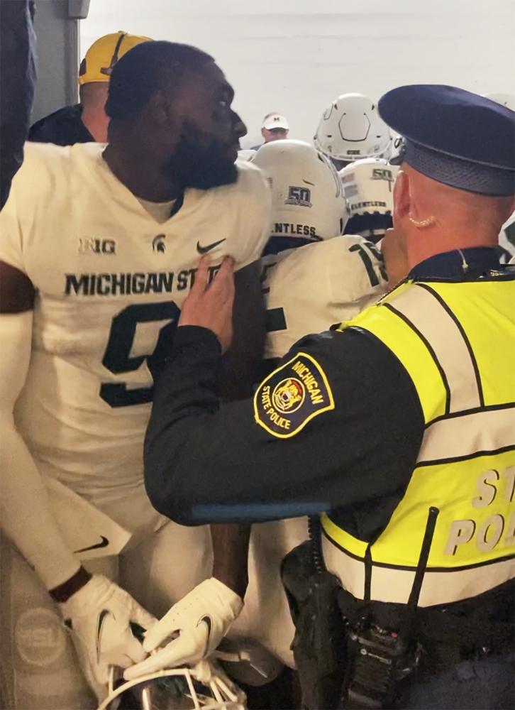 Security and police break up a scuffle between players from Michigan and Michigan State football teams in the Michigan Stadium tunnel after an NCAA college football game on Saturday, Oct. 29, 2022 in Ann Arbor, Mich. Michigan State President Samuel Stanley has apologized and says the actions of the football players who were involved in a postgame melee with Michigan players are “unacceptable.” He also says the players involved would be held responsible by coach Mel Tucker. (Kyle Austin/MLive Media Group via AP)