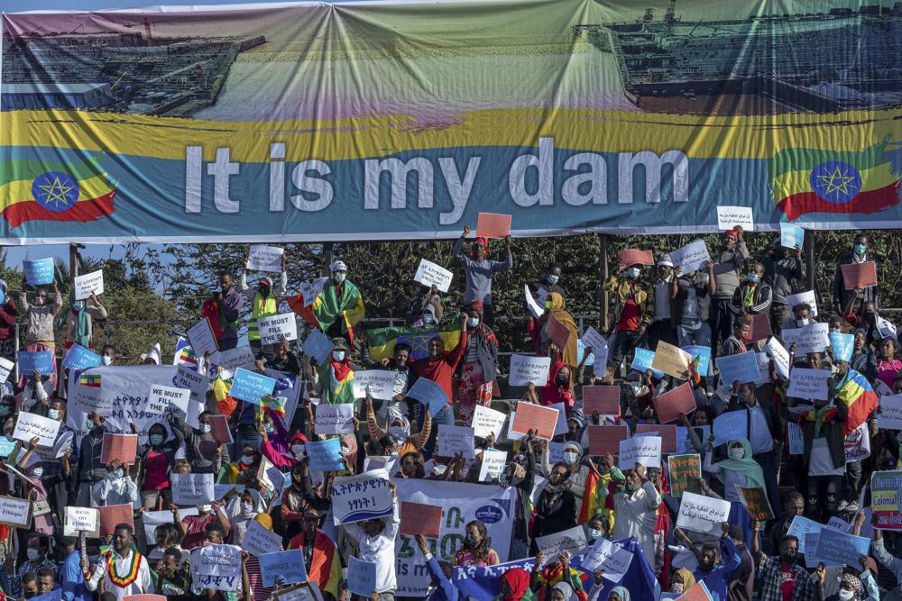 FILE - Ethiopians protest against international pressure on the government over the conflict in Tigray, below a banner referring to The Grand Ethiopian Renaissance Dam, at a demonstration organised by the city mayor's office held at a stadium in the capital Addis Ababa, Ethiopia on May 30, 2021. A senior Ethiopian official said Friday, June 10, 2022 his country is interested in resuming talks with Egypt and Sudan on the huge and controversial Blue Nile dam that will be Africa's largest hydroelectric power plant. (AP Photo/Mulugeta Ayene, File)