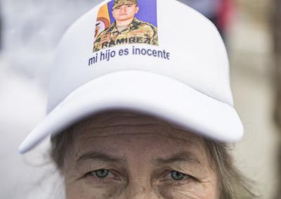 La madre de uno de los exmilitares que fue acusado de estar involucrado en el asesinato del presidente haitiano Jovenel Moise, lleva una gorra con una imagen de su hijo durante una manifestación en apoyo a sus seres queridos encarcelados, en la Plaza Bolívar, Bogotá, Colombia, el lunes 9 de agosto de 2021. Moise fue asesinado en su casa por un grupo armado de hombres el 7 de julio. (AP Foto/Ivan Valencia)
