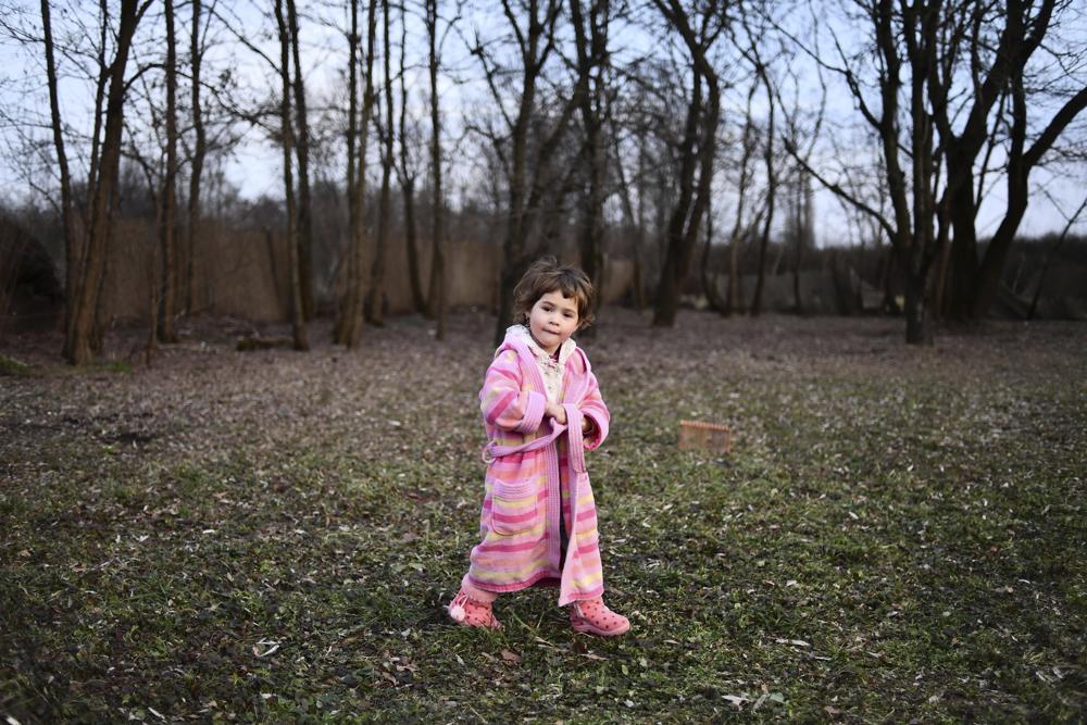 A young girl wears a robe as she walks through the back yard of a home hosted by the local Free Christian Church, for those fleeing Ukraine, in the village of Uszka, Hungary, Thursday, March 3, 2022. More than 1 million people have fled Ukraine following Russia's invasion in the swiftest refugee exodus in this century, the United Nations said Thursday. (AP Photo/Anna Szilagyi)