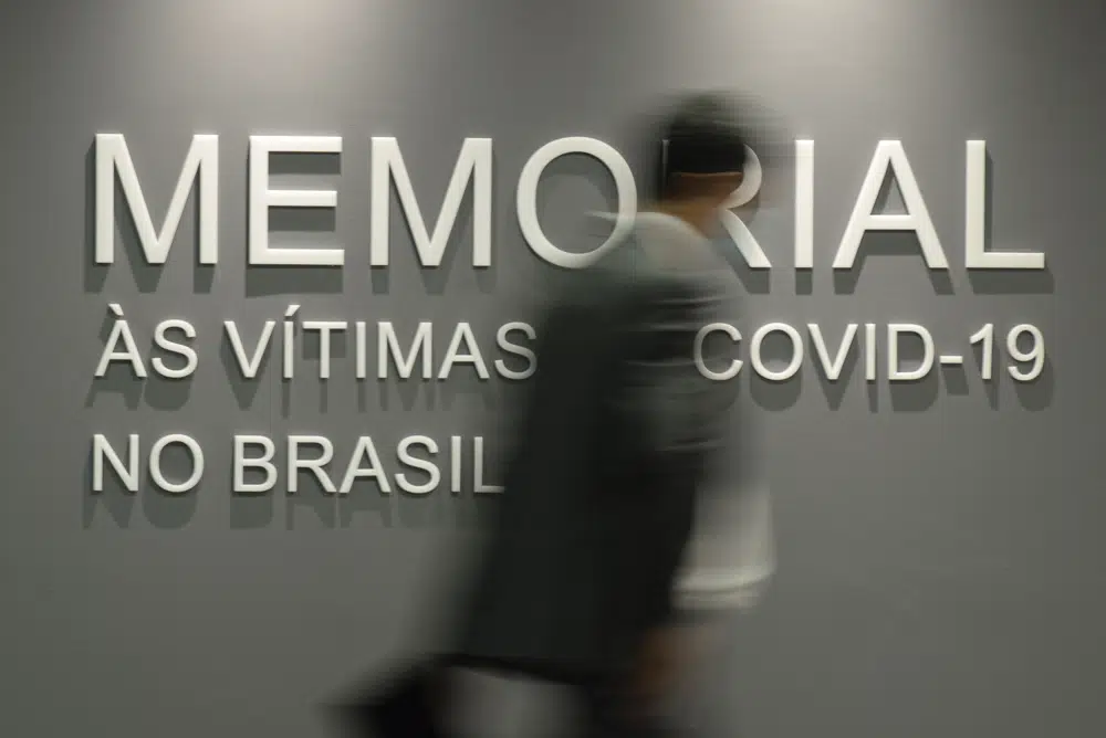 FILE - A man walks past a wall that reads in Portuguese "Memorial to the victims of COVID-19 in Brazil," in the Senate building in Brasilia, Brazil, Tuesday, Feb. 15, 2022. Brazil has officially recorded its 700,000th death from COVID-19, on Tuesday, March 28, 2023. (AP Photo/Claudio Reis, File)