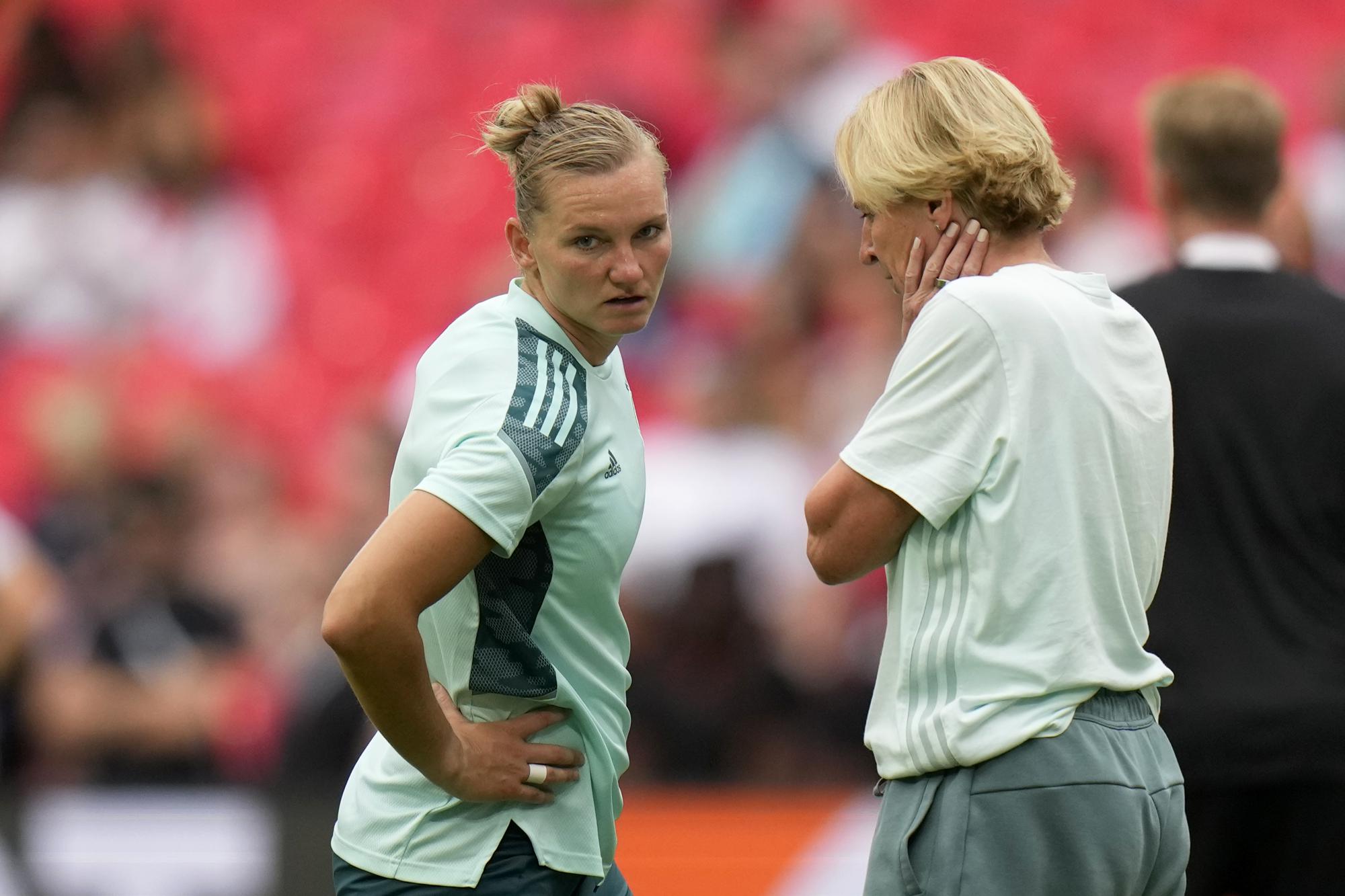 FILE - Germany's team captain Alexandra Popp, left, talks with Germany's manager Martina Voss-Tecklenburg during warmup before the Women's Euro 2022 final soccer match between England and Germany at Wembley stadium in London, Sunday, July 31, 2022. (AP Photo/Alessandra Tarantino, File)