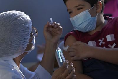 Personal de salud administra una dosis de la vacuna de Pfizer contra el COVID-19 en un centro de salud comunitario de Brasilia, el domingo 16 de enero de 2022. (AP Foto/Eraldo Peres)