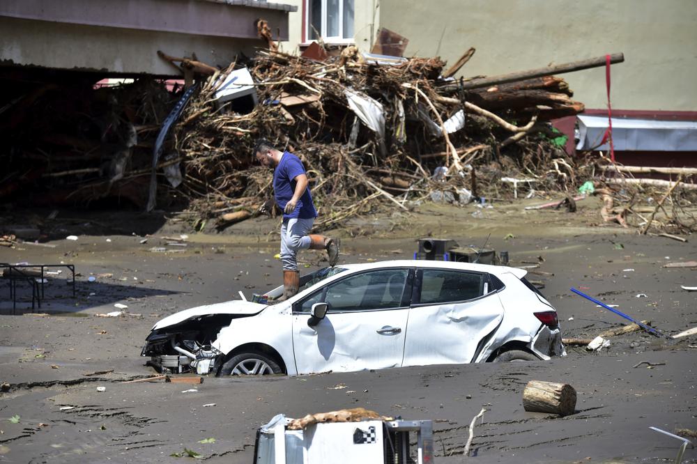 Un hombre revisa su auto enterrado en barro después de que inundaciones y deslaves golpearan el pueblo de Bozkurt en la provincia Kastamonu, Turquía, el viernes 13 de agosto de 2021. (AP Foto)