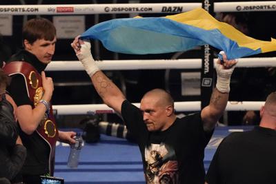 FILE - Oleksandr Usyk of Ukraine celebrates after his unanimous decision victory over Anthony Joshua of Britain in their WBA (Super), WBO and IBF boxing title bout at the Tottenham Hotspur Stadium in London, Saturday, Sept. 25, 2021. Former heavyweight champions Vitali and Wladimir Klitschko are leading some of the resistance from the mayor's office in beleaguered Kyiv. Two-time Olympic champion Vasiliy Lomachenko has an assault rifle and a place in a defense force, and current heavyweight champion Aleksandr Usyk rushed back home to take up arms against the Russians. Ukraine's rich boxing community is determined to fight, this time with guns instead of their fists. (AP Photo/Frank Augstein, File)