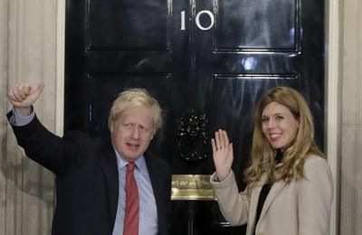 ARCHIVO - En imagen de archivo del 13 de diciembre de 2019, el primer ministro británico Boris Johson y su pareja, Carrie Symonds, saludan desde su residencia en 10 Downing Street en Londres. (AP Foto/Matt Dunham, archivo)