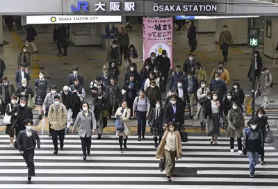 Personas portando mascarillas cruzan una calle en Osaka, en el oeste de Japón, el lunes 13 de marzo de 2023. (Yu Nakajima/Kyodo News vía AP)