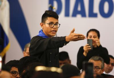 ARCHIVO - En esta fotografía de archivo del 16 de mayo de 2018, el representante estudiantil Lesther Alemán interrumpe al presidente de Nicaragua, Daniel Ortega, gritando que debe detener la represión durante la apertura de un diálogo nacional en las afueras de Managua, Nicaragua. (AP Foto/Alfredo Zuñiga, Archivo)